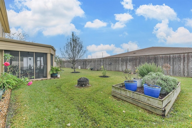 view of yard with a sunroom and a fire pit