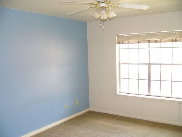 spare room featuring ceiling fan and light carpet