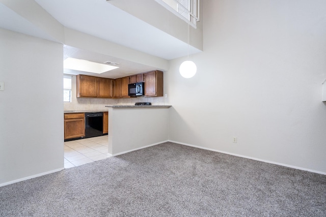 kitchen with kitchen peninsula, decorative light fixtures, light colored carpet, and black appliances