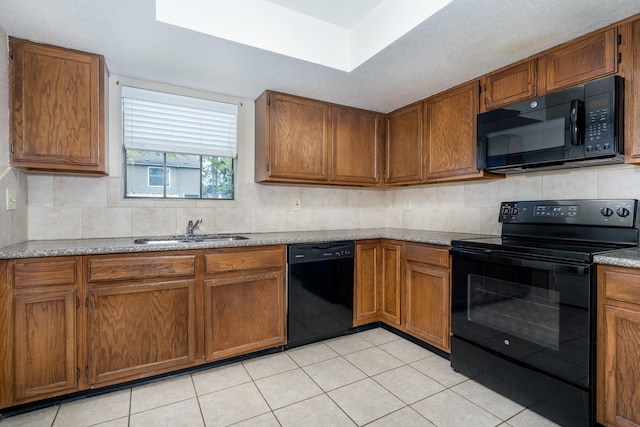 kitchen with backsplash, sink, light tile patterned floors, and black appliances