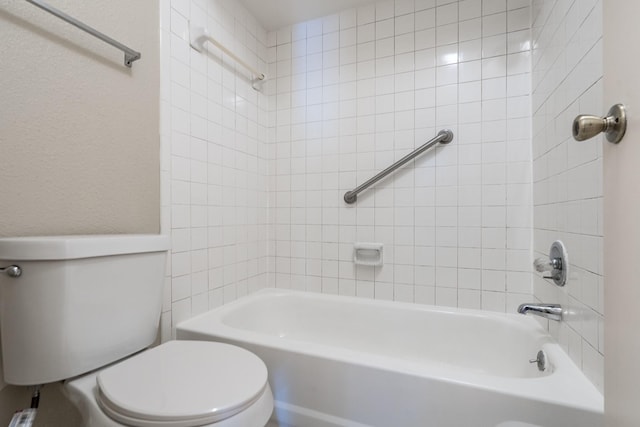 bathroom with tiled shower / bath combo and toilet