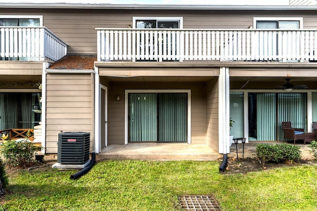 back of house with central air condition unit, ceiling fan, a balcony, and a yard