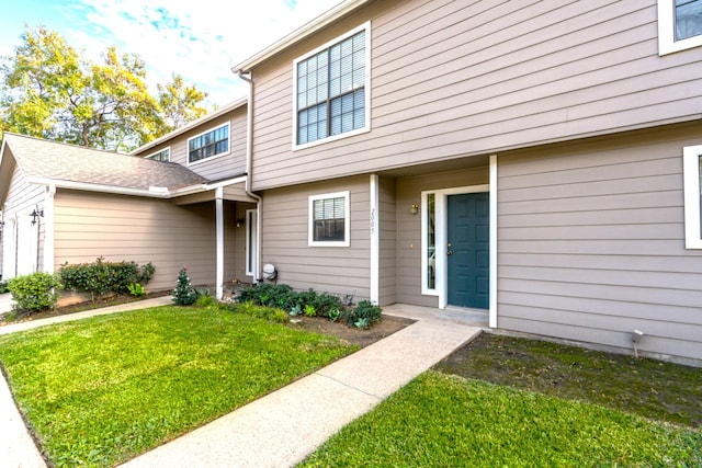 view of exterior entry featuring a yard