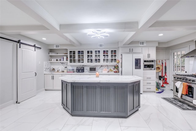 kitchen featuring white cabinets, a barn door, light stone countertops, and beamed ceiling