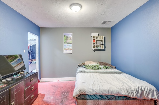 bedroom with carpet and a textured ceiling