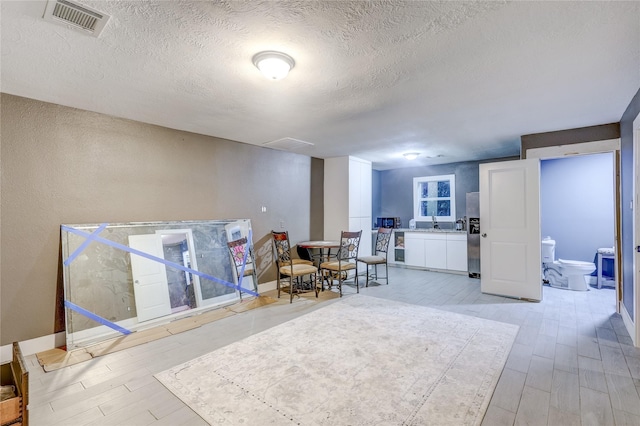 interior space with light hardwood / wood-style floors and a textured ceiling