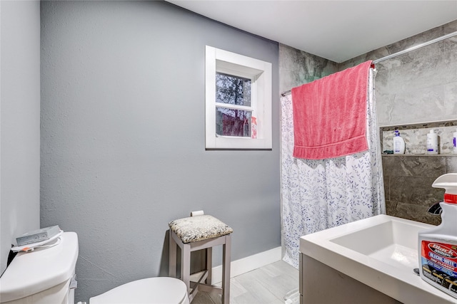 bathroom with a shower with curtain, sink, and toilet