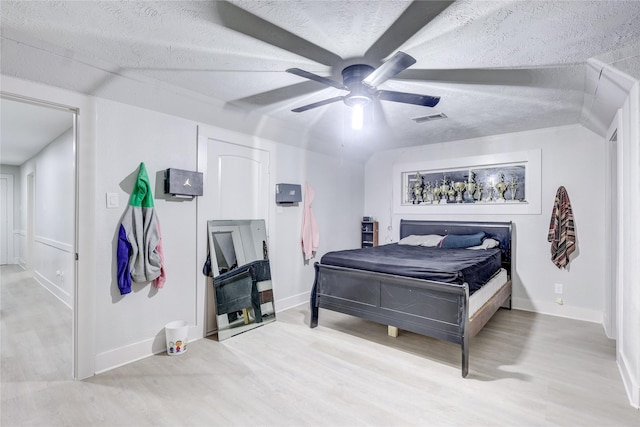 bedroom with ceiling fan, a textured ceiling, and light wood-type flooring