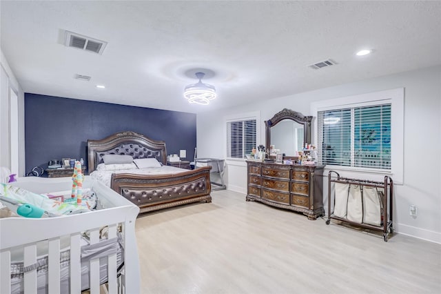 bedroom with hardwood / wood-style floors and a textured ceiling