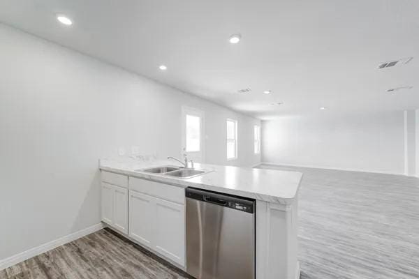 kitchen with white cabinetry, stainless steel dishwasher, light hardwood / wood-style floors, and sink