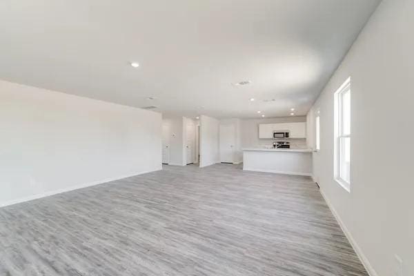 365 E Northpointe Ave, La Grange, TX 78945 - unfurnished living room with light wood-style floors, baseboards, and recessed lighting
