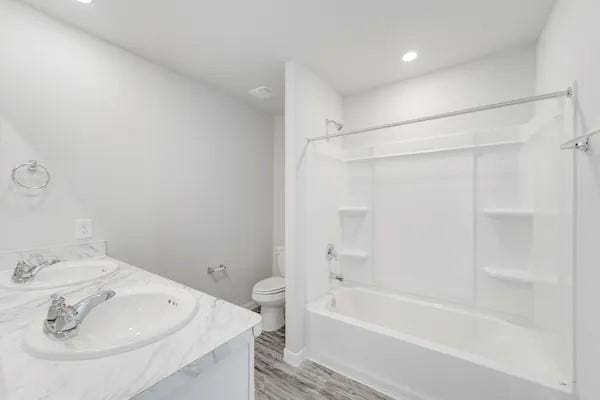 365 E Northpointe Ave, La Grange, TX 78945 - full bath featuring toilet, double vanity, tub / shower combination, wood finished floors, and recessed lighting