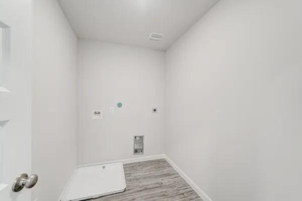 clothes washing area featuring electric dryer hookup and hardwood / wood-style floors