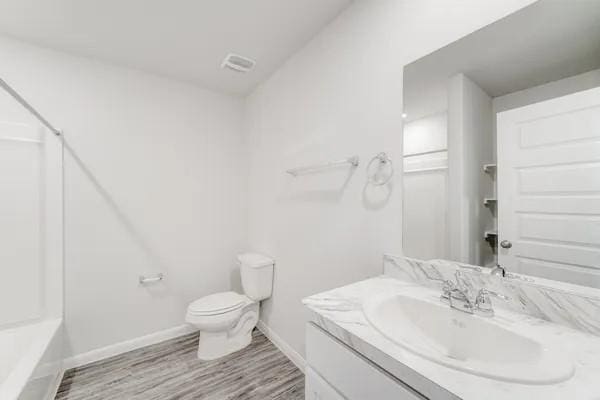 bathroom with vanity, wood-type flooring, and toilet