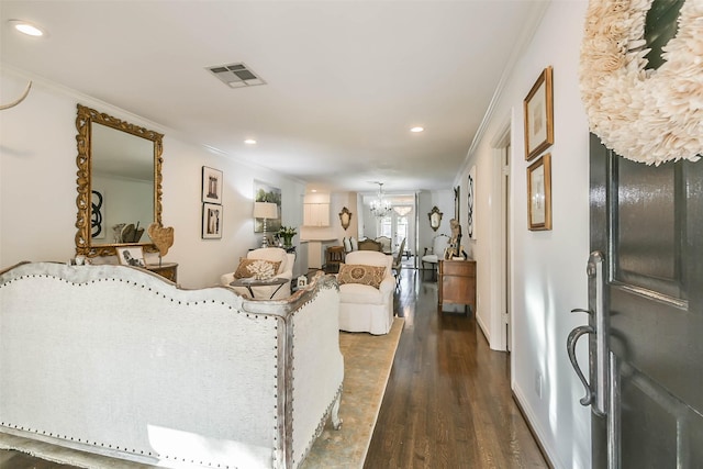 living room featuring a chandelier, dark hardwood / wood-style floors, and ornamental molding