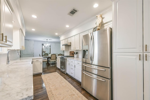 kitchen featuring light stone countertops, appliances with stainless steel finishes, ornamental molding, white cabinets, and dark hardwood / wood-style floors