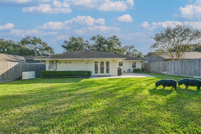 back of house with a yard, french doors, and a patio