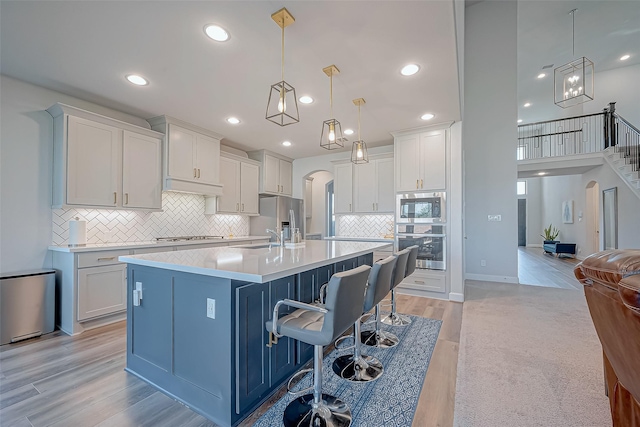 kitchen featuring pendant lighting, light wood-type flooring, and white cabinetry