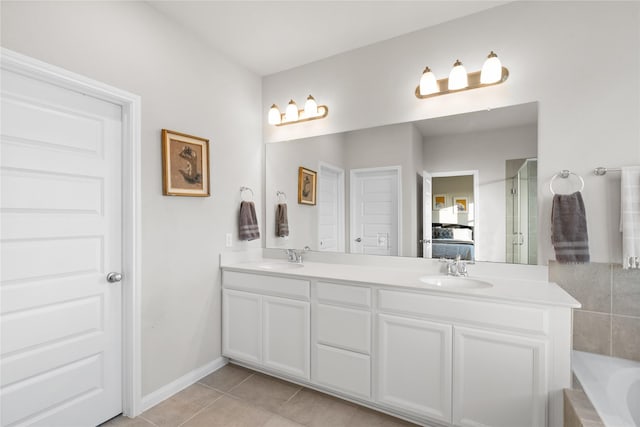 bathroom featuring tile patterned flooring, vanity, and a bath