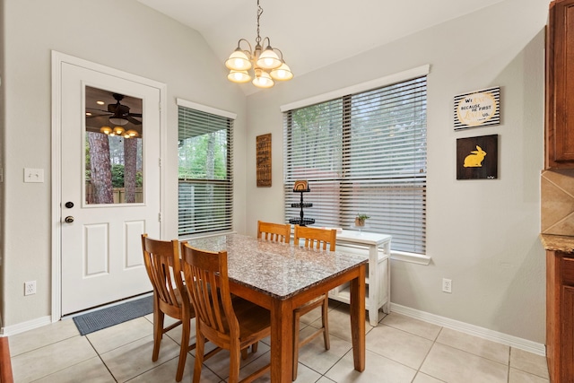 tiled dining area with ceiling fan with notable chandelier and vaulted ceiling