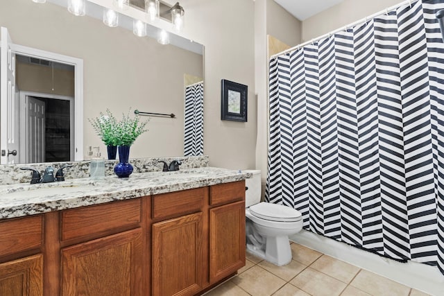 bathroom featuring tile patterned flooring, vanity, toilet, and walk in shower