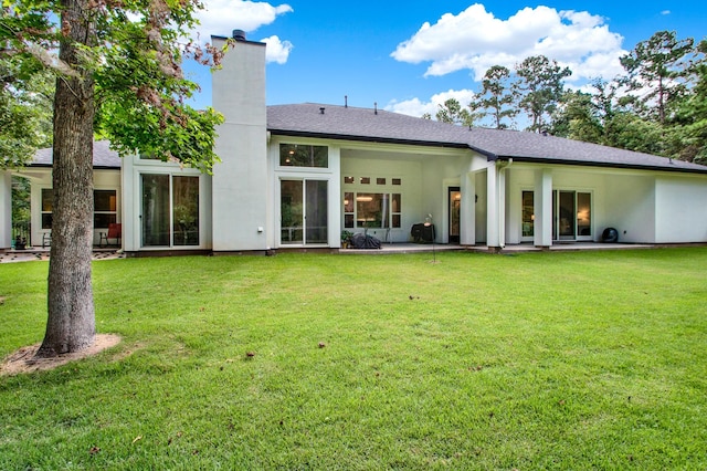 rear view of property with a lawn