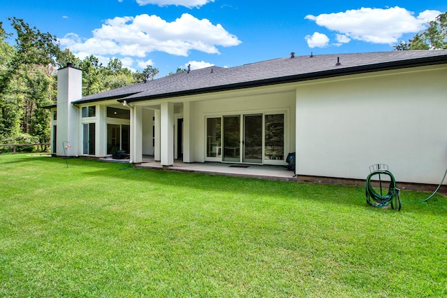 rear view of property with a patio area and a lawn