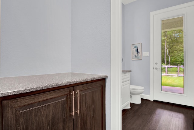 bathroom featuring toilet, hardwood / wood-style floors, and vanity