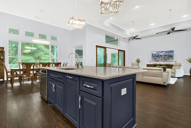 kitchen featuring dark hardwood / wood-style floors, hanging light fixtures, a kitchen island with sink, ceiling fan, and sink