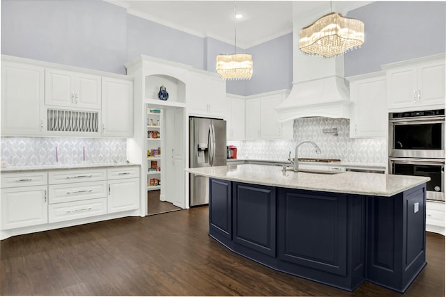 kitchen featuring decorative light fixtures, an inviting chandelier, white cabinets, appliances with stainless steel finishes, and sink