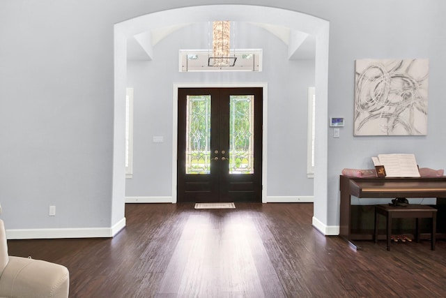 foyer featuring french doors, a chandelier, and dark hardwood / wood-style floors