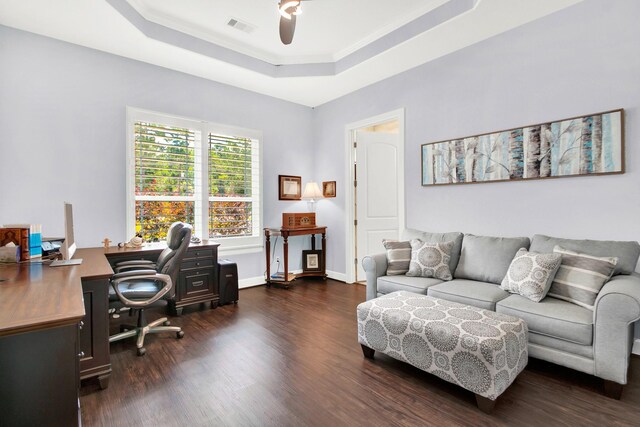 office space with ceiling fan, dark hardwood / wood-style flooring, crown molding, and a tray ceiling