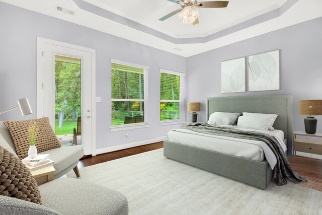 bedroom with a raised ceiling, access to exterior, ceiling fan, hardwood / wood-style flooring, and crown molding