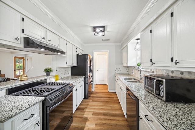 kitchen with light stone countertops, white cabinetry, sink, and appliances with stainless steel finishes