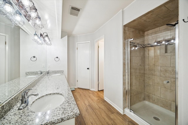 bathroom with hardwood / wood-style floors, vanity, and walk in shower