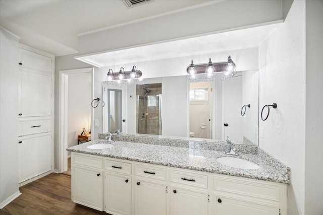 bathroom featuring vanity, hardwood / wood-style flooring, toilet, and a shower with door