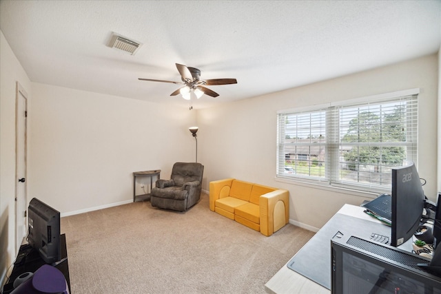 living area with ceiling fan and light colored carpet