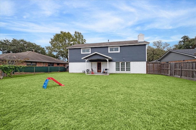 back of house with a patio area and a lawn