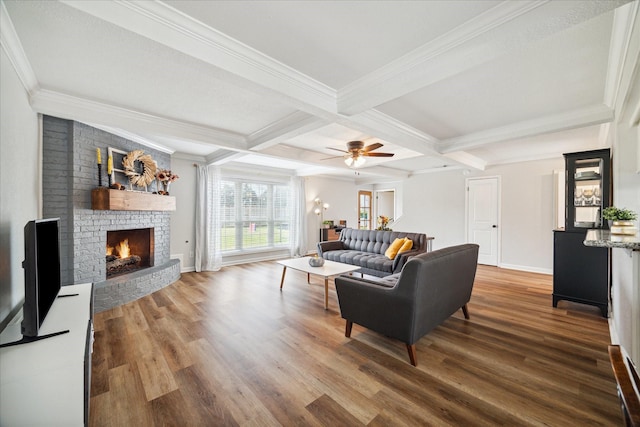 living room with beamed ceiling, ornamental molding, ceiling fan, and coffered ceiling