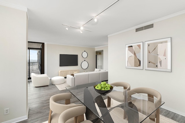 dining room with crown molding and hardwood / wood-style flooring