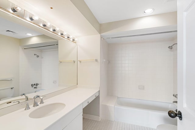 bathroom featuring tile patterned flooring, vanity, and tiled shower / bath combo