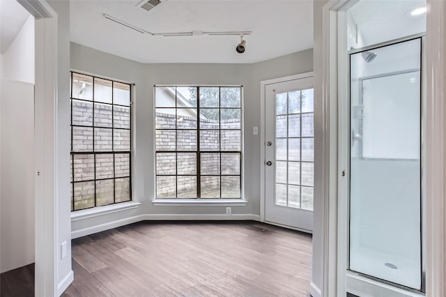 interior space with track lighting and light hardwood / wood-style floors