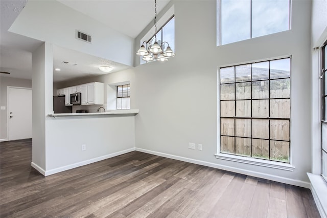 interior space with hardwood / wood-style floors, a high ceiling, and a wealth of natural light