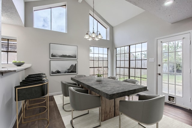 dining room featuring hardwood / wood-style floors, high vaulted ceiling, and a chandelier