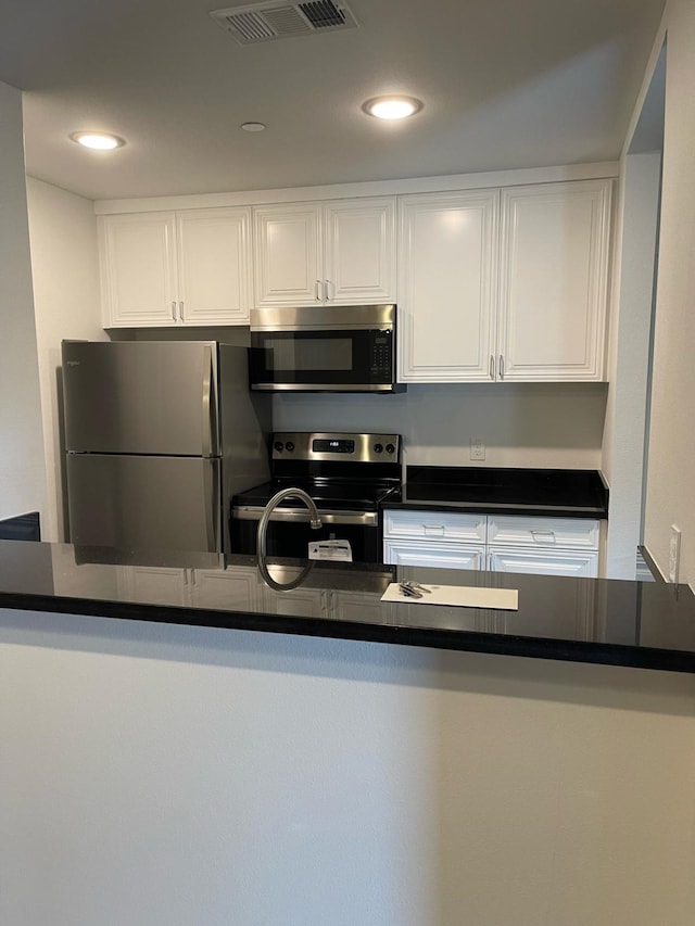 kitchen with white cabinets, stainless steel appliances, and kitchen peninsula