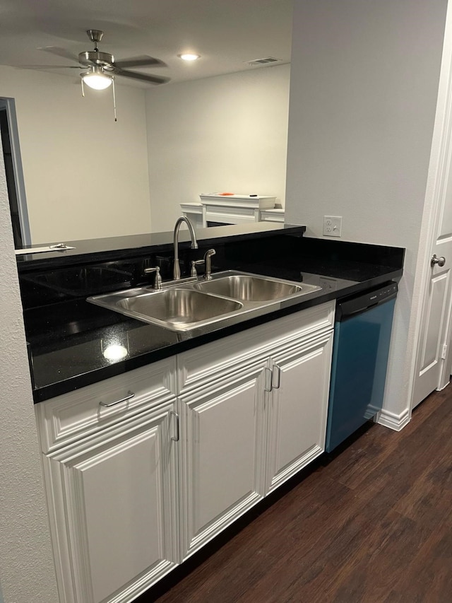 kitchen with dishwashing machine, dark countertops, a sink, and white cabinetry