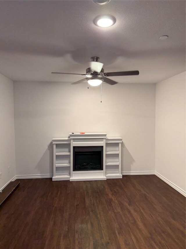 unfurnished living room featuring a textured ceiling, dark hardwood / wood-style floors, and ceiling fan