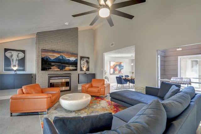 living room featuring ceiling fan, a brick fireplace, and vaulted ceiling