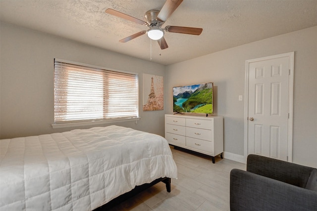 bedroom with a textured ceiling and ceiling fan