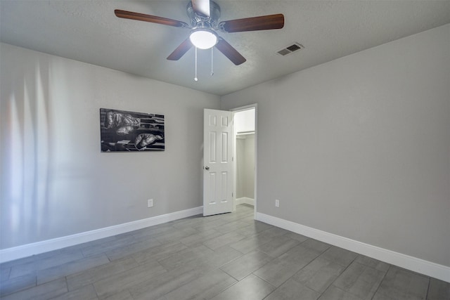 spare room featuring ceiling fan and a textured ceiling